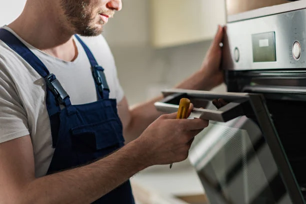 Technician inspecting a stainless steel oven door