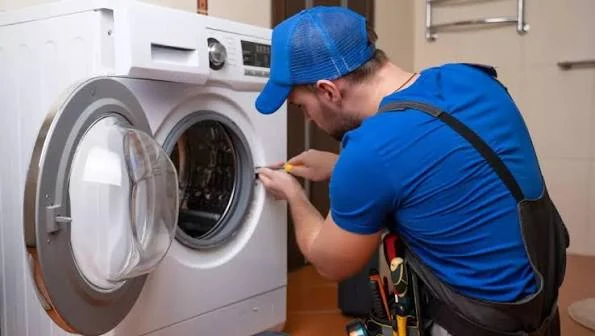 Technician inspecting the door opening of a front-loading washing machine